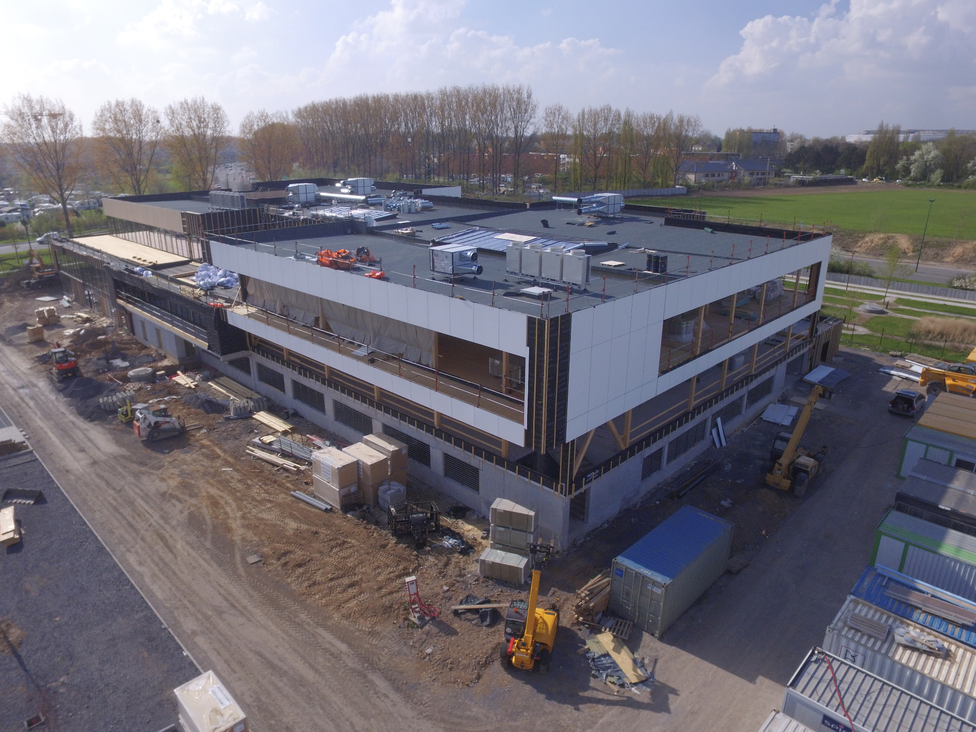 Aerial view of a multi-storey building under construction with structural timber and white cladding