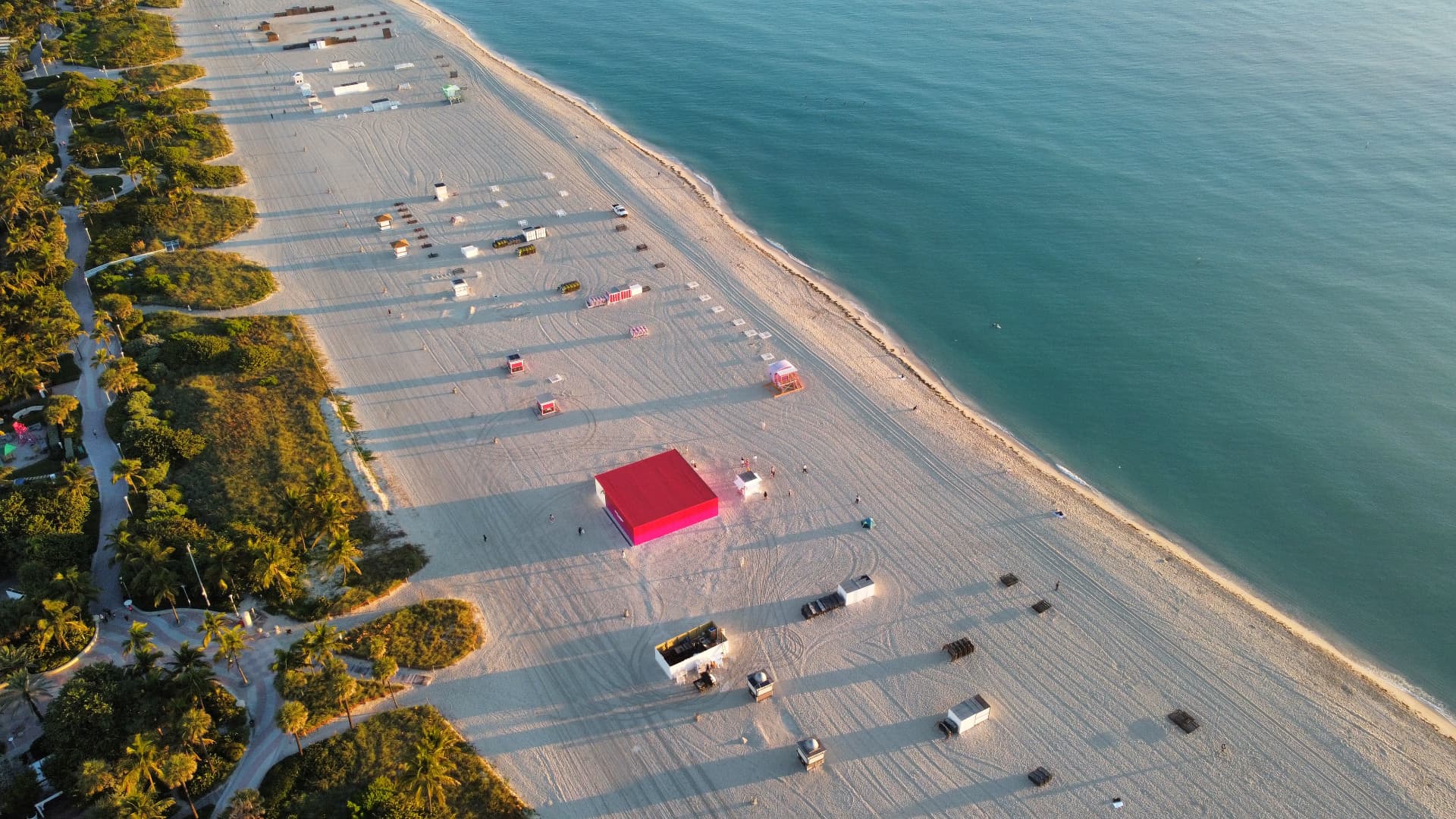 Aerial top-down view of Miami Beach sand, palm groves and turquoise water
