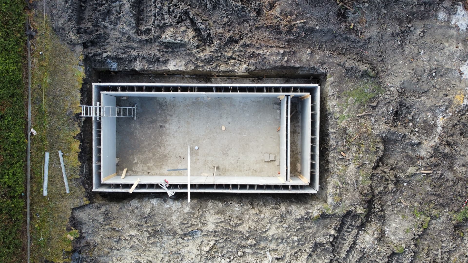 Top-down aerial view of a rectangular concrete foundation structure under construction